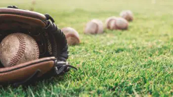 Baseball idioms - a close up of a catcher mitt and baseballs on the grass