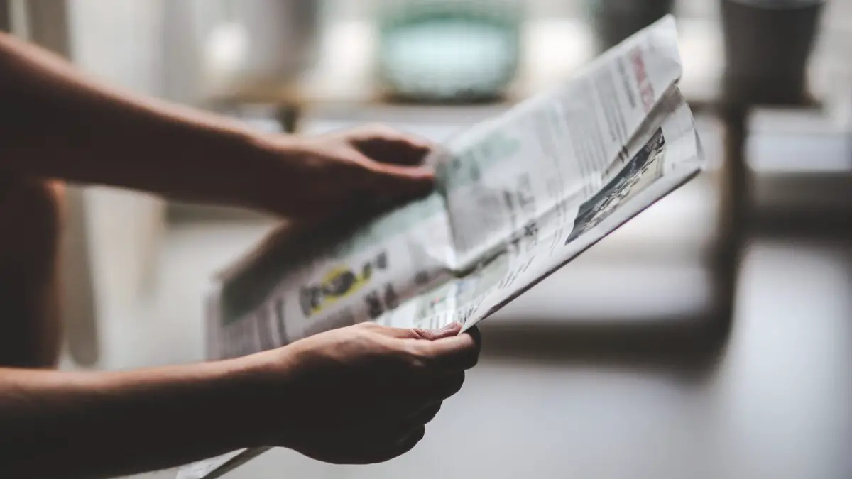 man trying to learn english with news in a newspaper