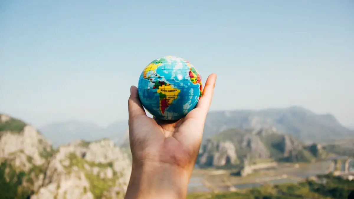 Adventure idioms - a close of up someone holding a small globe