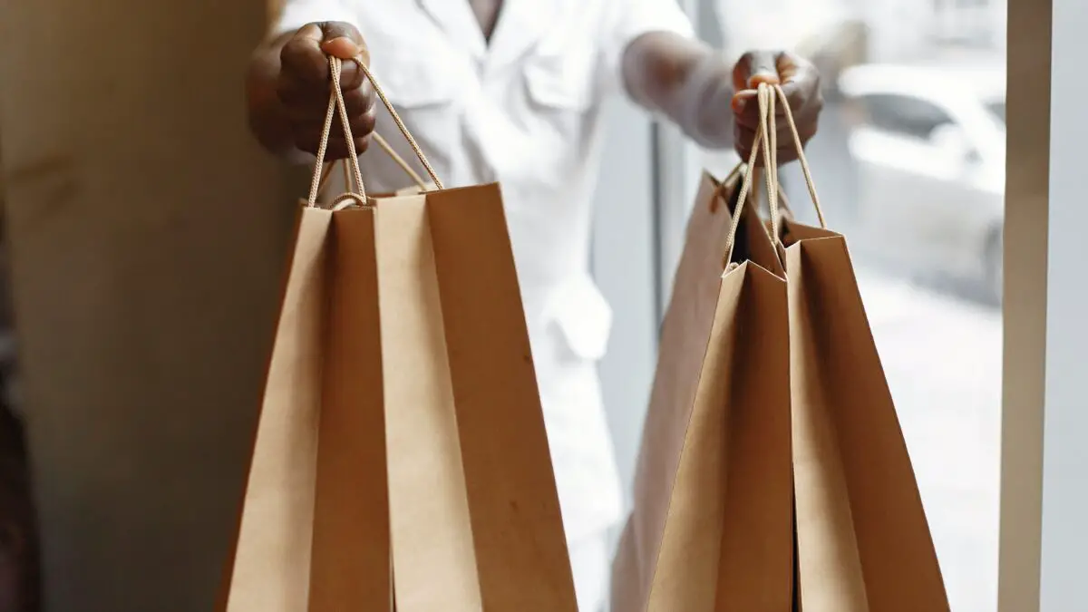 Shopping idioms - someone holding out two brown paper bags