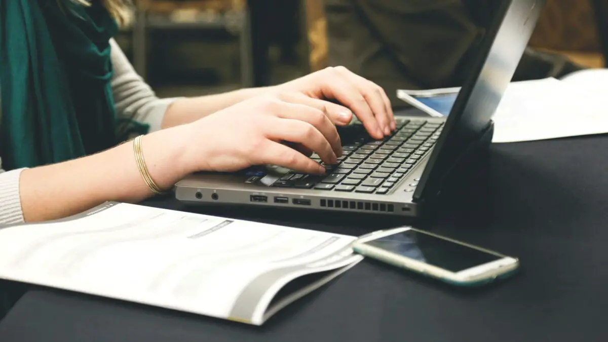 improve your english writing for business - person typing on a laptop
